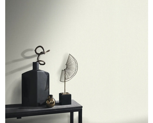 Dekorativa vaser och skulpturer på ett bord framför en vägg