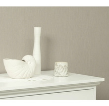 Dekorativa element på en byrå framför en tapet