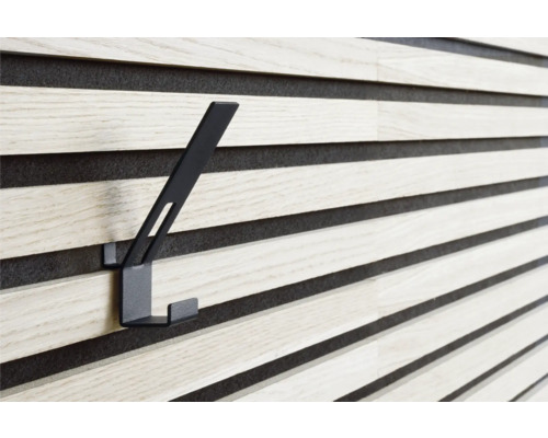 Svart klädkrok på en träpanelvägg