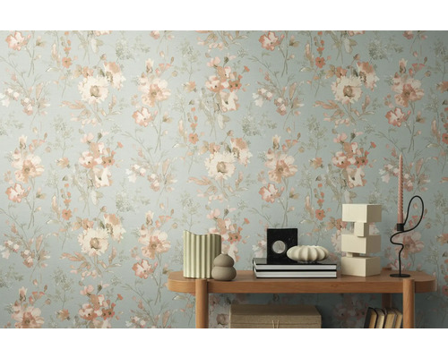 Närbild av en vägg med blommig tapet och ett sidobord med dekorativa föremål.