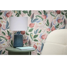 Scen med blommig tapet, bordslampa och sidobord
