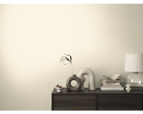 Vardagsrum med byrå, bordslampa, böcker och dekorationer.