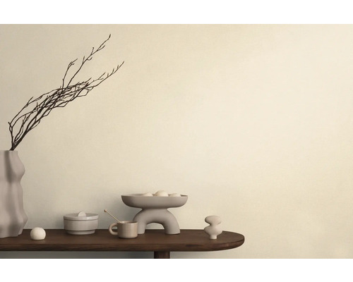 Dekorativt arrangemang med vas, grenar, skål och keramikobjekt på ett bord.