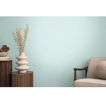 Vardagsrum med fåtölj, träbord och dekorativ vas