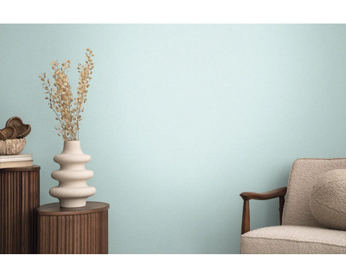 Vardagsrum med fåtölj, träbord och dekorativ vas