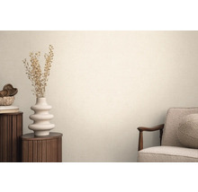 Vardagsrum med textiltapet, fåtölj, runt sidobord och dekoration