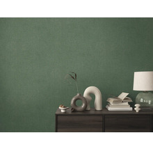 Närbild av en grön textiltapet på en vägg bakom ett skåp.