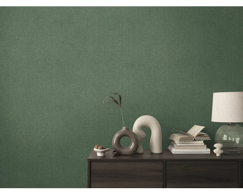 Närbild av en grön textiltapet på en vägg bakom ett skåp.