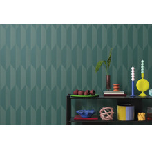 Mönstrat vardagsrum med hylla och dekoration mot en mönstrad tapetbakgrund