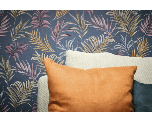 Dekorativ tapet med bladmönster och kuddar i förgrunden.