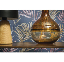 Dekorativ scen med en lampa, en vas och en mönstrad tapet.