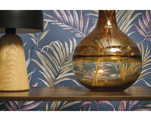 Dekorativ scen med en lampa, en vas och en mönstrad tapet.