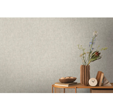 Närbild av en ljus vägg med en subtilmönstrad tapet som skapar en lugn och enhetlig textur.