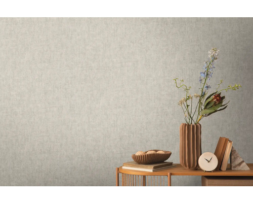 Närbild av en ljus vägg med en subtilmönstrad tapet som skapar en lugn och enhetlig textur.