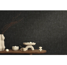 Stilfull rumsinredning med mörk non-woven tapet och dekorativa element på ett träbord.