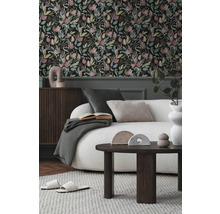Vardagsrum med blommig tapet, soffa, soffbord och dekorativa element för en stilfull inredning