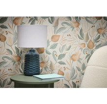 Scen med blommönstrad tapet, bordslampa och bok på sidobord