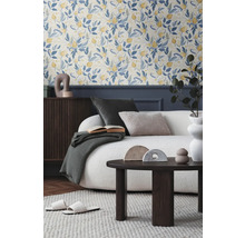 Vardagsrum med blommig tapet, soffa, soffbord och dekorativa tillbehör för en mysig atmosfär.