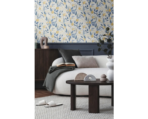 Vardagsrum med blommig tapet, soffa, soffbord och dekorativa tillbehör för en mysig atmosfär.