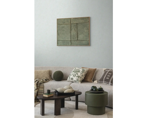 Vardagsrum med soffa, kuddar, soffbord och väggdekoration för en mysig atmosfär