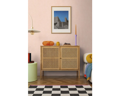 Vardagsrum med rottingbyrå, konstverk och dekorativa tillbehör för en stilfull inredning