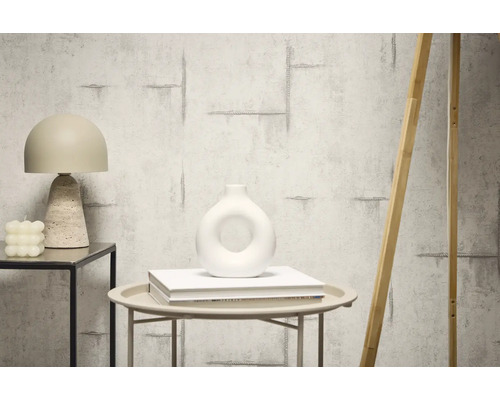 Dekorativ inredning med tapet i betonglook, bordslampa och vas