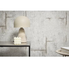 Dekorativ bordslampa bredvid ett kubljus på ett bord