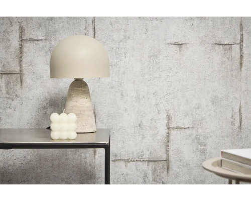 Dekorativ bordslampa bredvid ett kubljus på ett bord