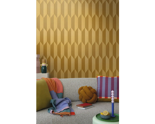 Miljöbild med en soffa och en vägg med geometrisk tapet