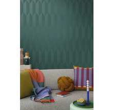 Vardagsrum med grå soffa, kuddar, filtar och mönstrad tapet för en stilfull inredning.