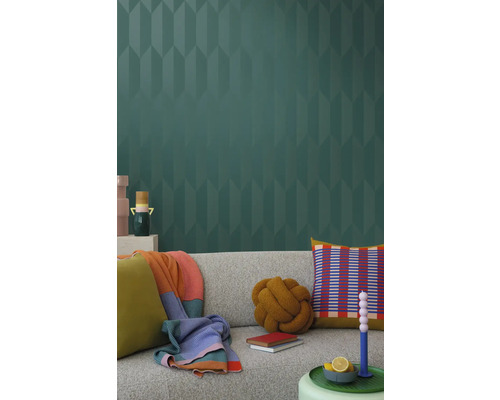 Vardagsrum med grå soffa, kuddar, filtar och mönstrad tapet för en stilfull inredning.