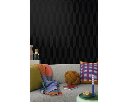 Vardagsrum med svart tapet med geometriskt mönster och soffa