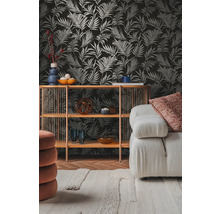 Vardagsrum med mönstrad tapet, hylla och soffa