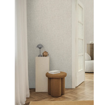 Ljust rum med mönstrad tapet, pall och dekorationer för en stilfull inredning.