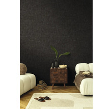 Vardagsrum med mörk tapet, nattduksbord och sittmöbler för en mysig atmosfär.