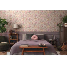 Sovrum med blommig tapet, säng och trämöbler för en mysig atmosfär.