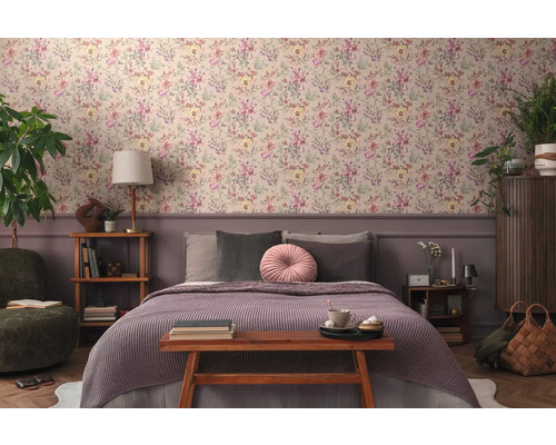 Sovrum med blommig tapet, säng och trämöbler för en mysig atmosfär.