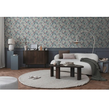 Vardagsrum med mönstrad tapet, soffa, matta och träelement för en mysig atmosfär