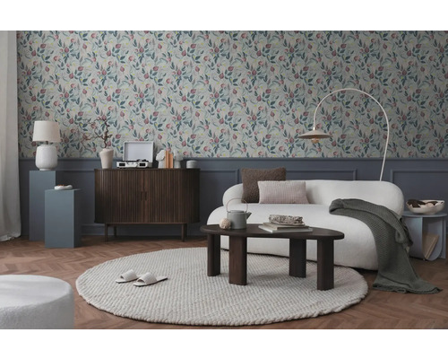 Vardagsrum med mönstrad tapet, soffa, matta och träelement för en mysig atmosfär