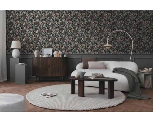 Vardagsrum med blommig tapet, soffa, matta och trädetaljer för en mysig atmosfär
