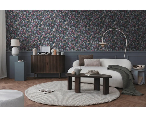 Vardagsrum med blommig tapet, soffa och möbler