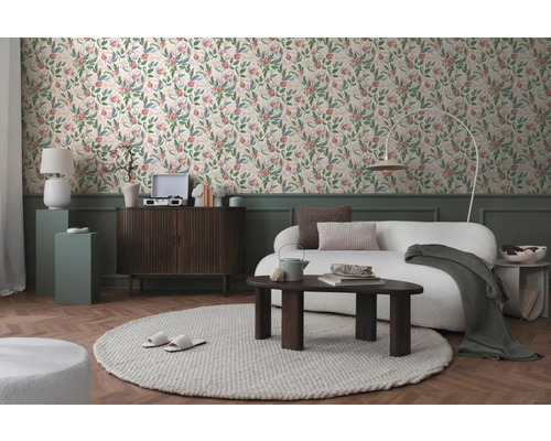 Vardagsrum med soffa, matta och blommig tapet