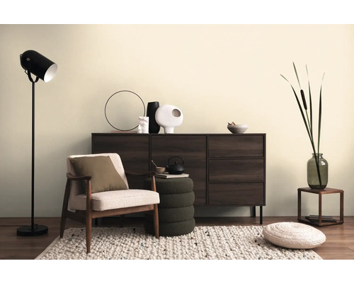 Vardagsrumsscen med byrå, fåtölj, golvlampa och dekorativa element på en matta