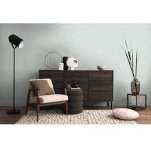 Vardagsrum med byrå, fåtölj, golvlampa och dekorativa element för en mysig atmosfär