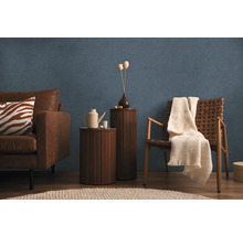 Vardagsrum med soffa, fåtölj, sidobord och dekor på blå strukturtapet