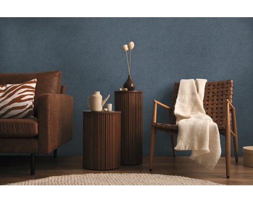 Vardagsrum med soffa, fåtölj, sidobord och dekor på blå strukturtapet