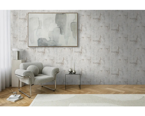 Vardagsrum med mönstrad tapet, fåtölj och konstverk