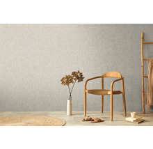 Scen med non-woven tapet på väggen, stol, dekoration och matta.