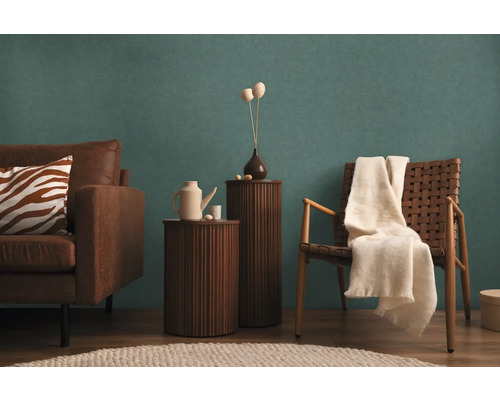 Vardagsrum med soffa, fåtölj, sidobord och dekorativa element för en mysig atmosfär.