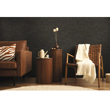 Vardagsrum med soffa, fåtölj och sidobord framför en mörk vägg